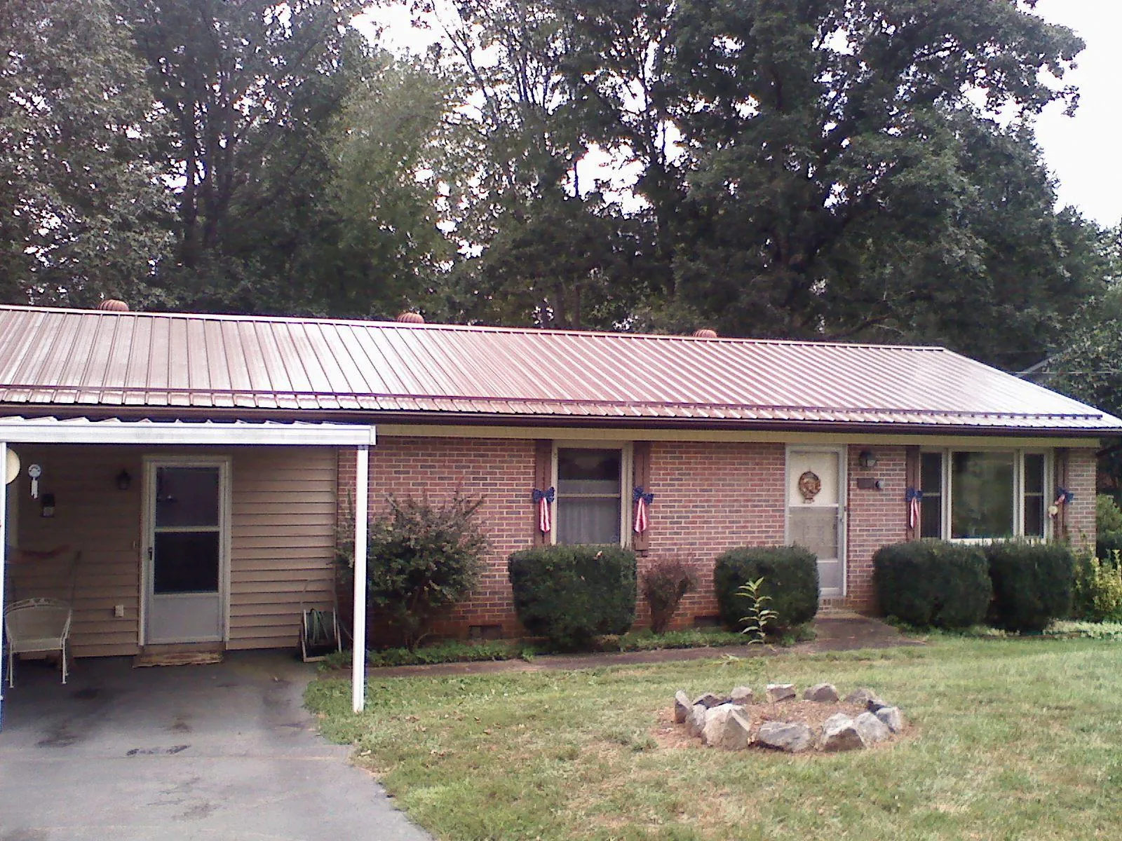 Bronze metal roof and carport on a brick ranch home — Roof Repair work by our crew in Greeleyville